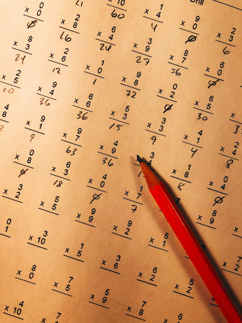 A worksheet of multiplication problems with a red pencil