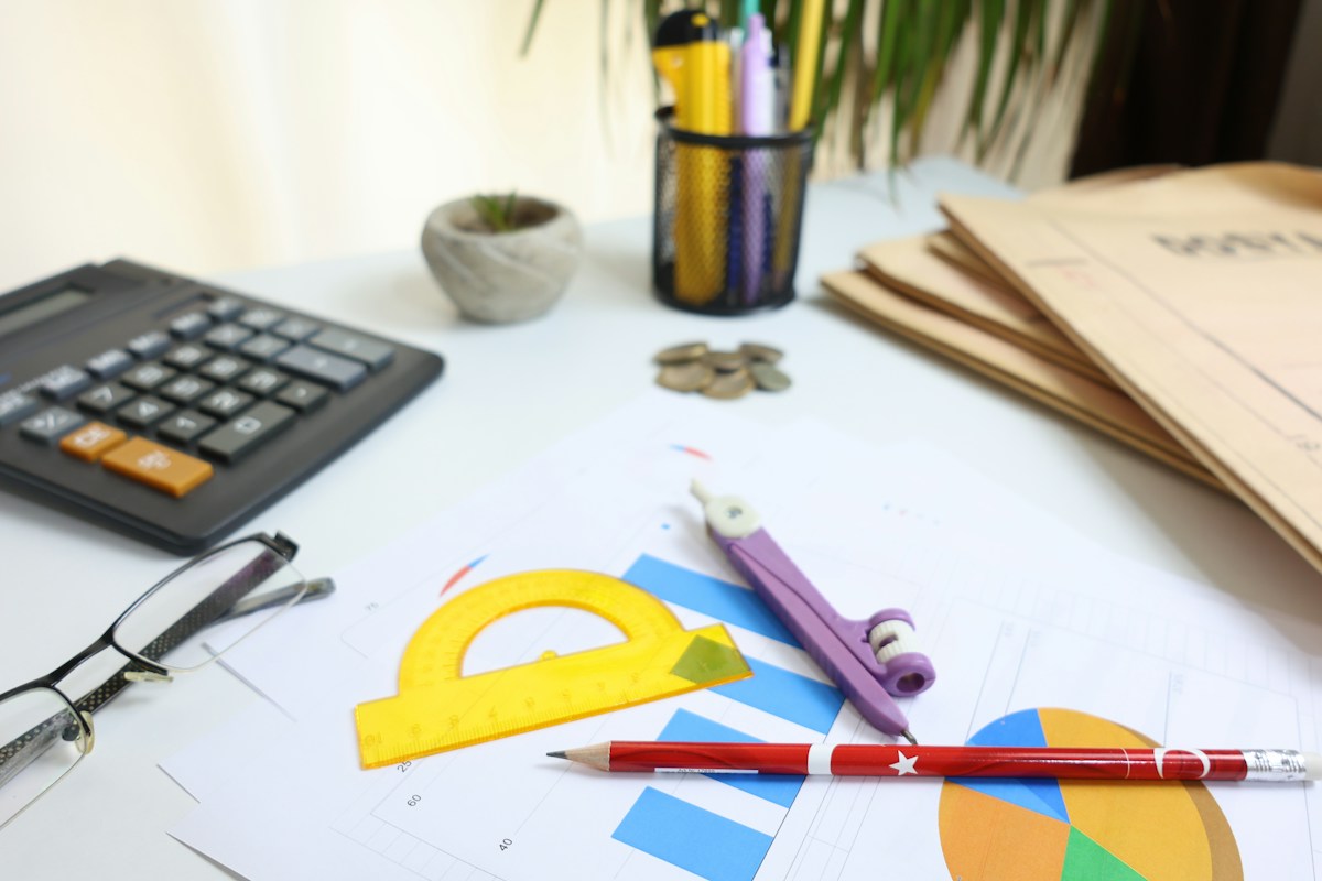 A study desk with a calculator, protractor and Math worksheets