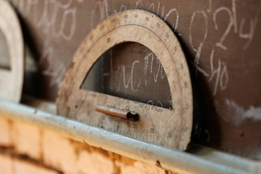 A wooden protractor resting on a chalkboard